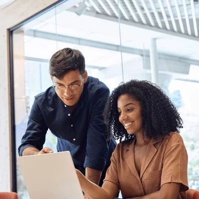 Dos personas colaborando frente a un computador portátil
