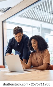 Dos personas colaborando frente a un computador portátil