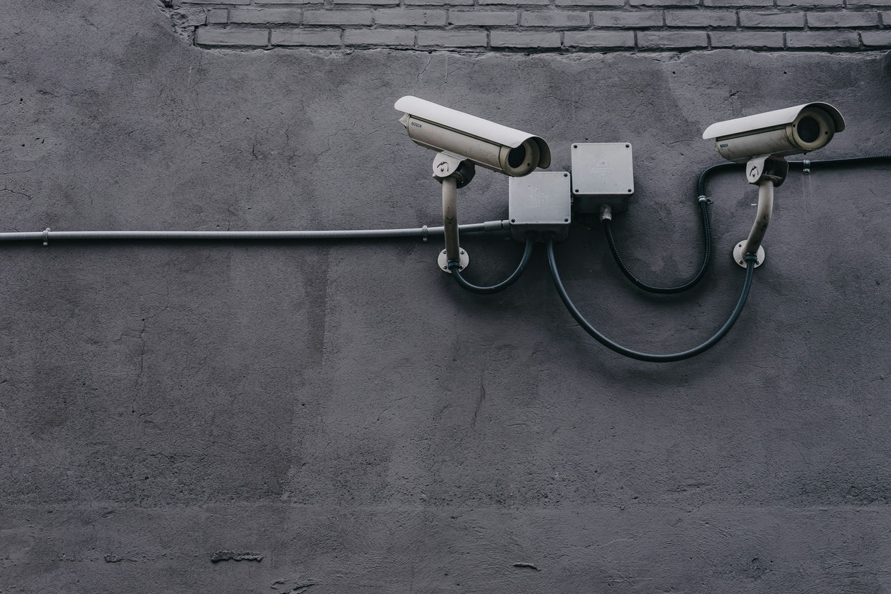 Dos cámaras de seguridad tipo domo instaladas sobre una pared gris