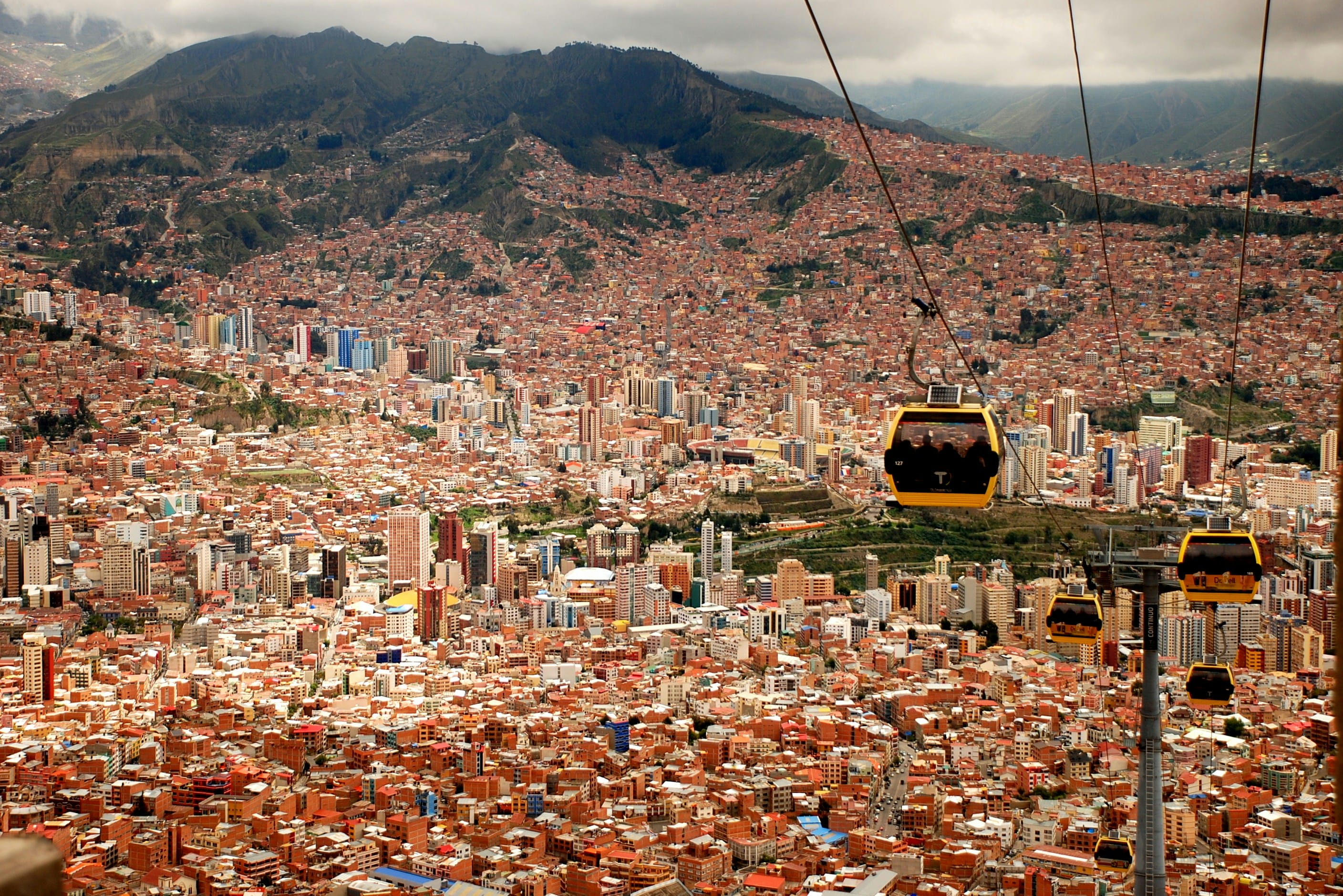 Cabina del sistema Mi Teleférico sobrevolando la densa arquitectura urbana de la ciudad de La Paz.