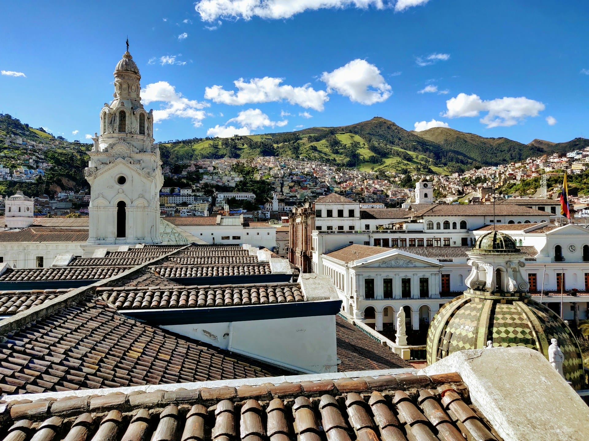 Vista panorámica sobre los tejados de arcilla del centro histórico de Quito con la Basílica al fondo.