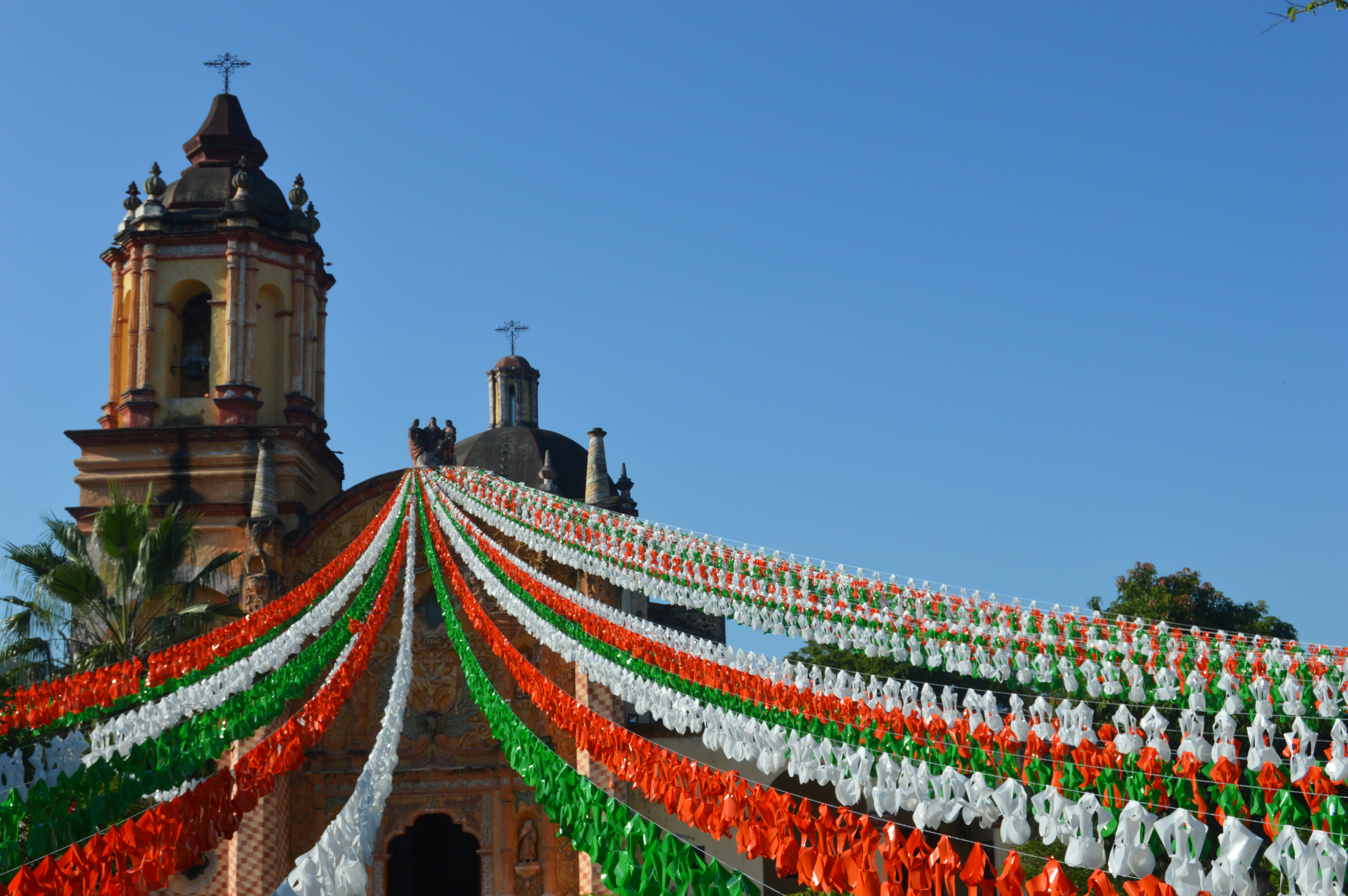 Templo colonial decorado con guirnaldas tricolores verde, blanco y rojo en sus festividades.